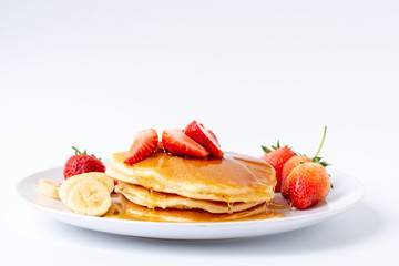 Homemade Pancakes with fresh strawberries and slice banana and honey on white plate,Healthy breakfast.