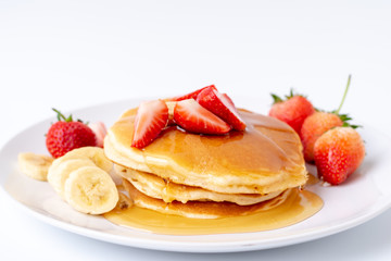 Homemade Pancakes with fresh strawberries and slice banana and honey on white plate,Healthy breakfast.