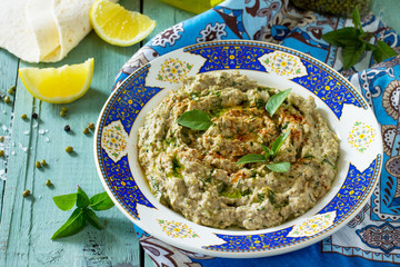 Arabic cuisine. Fresh homemade creamy mung hummus with spicy, falafel, sour cream sauce on a wooden kitchen table. Ramadan food.
