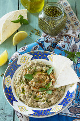 Arabic cuisine. Fresh homemade creamy mung hummus with spicy, falafel, sour cream sauce on a wooden kitchen table. Ramadan food. Top view flat lay background.