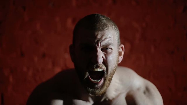 Portrait of angry man on red background.