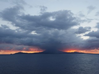 Wide shot of a beautiful sunrise with dark heavy clouds hanging over Nevis Island near St. Kitts, West Indies