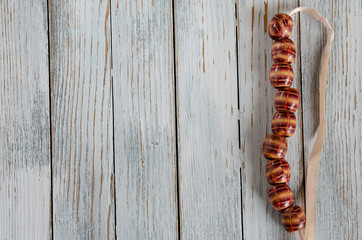bracelet from large wooden beads on a light background. Handmade. Concept for summer. Copyspace