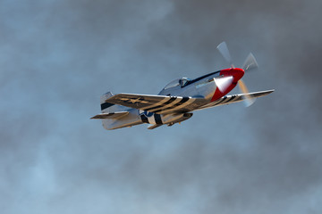 P51D Mustang (WWII American fighter plane) in beautiful light, against smoke
