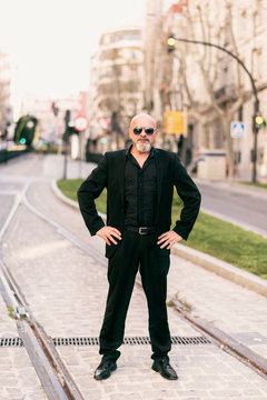 Full length portrait of suit senior man posing in the city
