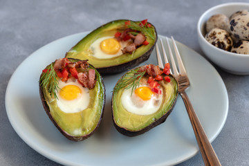 Quail eggs baked in avocado with bacon, red paprika and dill.
