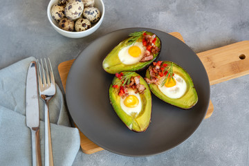 Quail eggs baked in avocado with bacon, red paprika and dill.