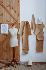 Fototapeta na wymiar Sewing Studio. The workplace of a tailor. Mannequins for sewing on the background of a wooden wall