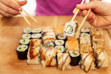 People eat rolls with chopsticks, close-up