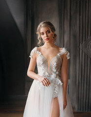 charming pretty lady with a light fluffy white dress, magnificent detailed goon tailoring, excellent work of a photographer and make-up artist, a swan princess costume with a bare leg in the cut