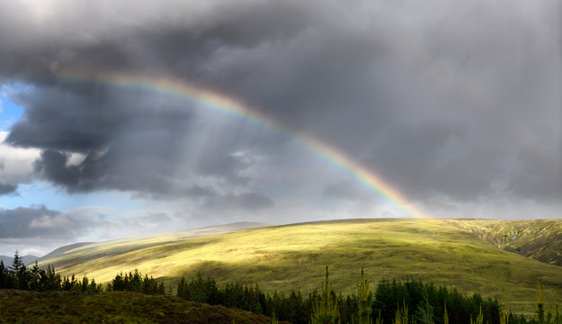 Double rainbow and dark clouds on An Liathanach mountain at Loch a Chroisg near Badavanich Scottish Highlands Scotland UK © Reimar