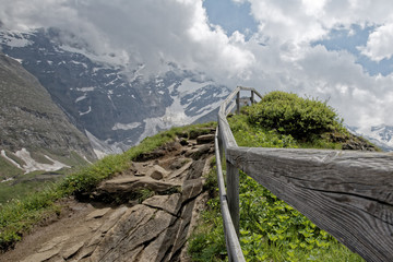 Fototapeta na wymiar Wooden railings are set along the mountain path