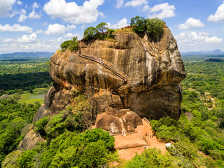 Aerial view from above of Sigiriya or the Lion Rock, an ancient fortress and a palace with gardens, pools, and terraces atop of granite rock in Dambulla, Sri Lanka. Surrounding jungles and landscape