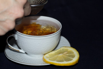 A mug of tea with lemon and chocolate.