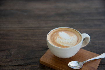 a cup of coffee on wood table, latte art