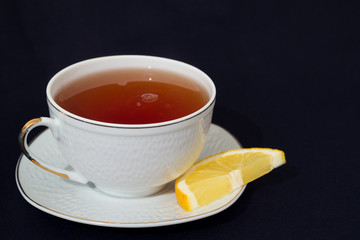 A mug of tea with lemon and chocolate.
