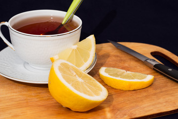 A mug of tea with lemon and chocolate.