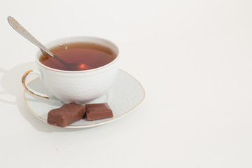 A mug of tea with lemon and chocolate.