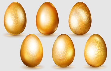 Set of realistic golden Easter eggs with glares and soft shadows on white background