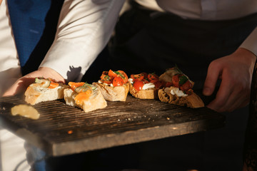 A waiter with a tray of snacks at a banquet or reception. Catering buffet at party