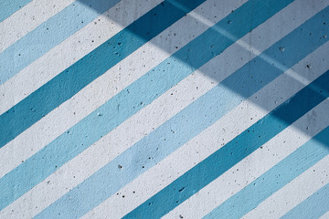 Painted concrete wall with diagonal blue and blue stripes and shadows - 252491101