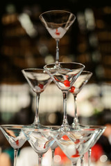 Champagne slide. Pyramid or fountain made of champagne glasses with cherry and steam from dry ice