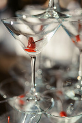 Champagne slide. Pyramid or fountain made of champagne glasses with cherry and steam from dry ice