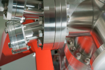 Detail of vacuum equipment with steel flanges bolted to the vessel in laboratory or industrial environment. Abstract industrial or technology background.