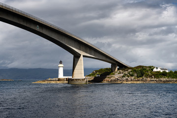 Skye Bridge over Kyle Akin Strait from Inner Sound to Loch Alsh and Eilean Ban Island with white Kyleakin lighthouse and cottages Scotland