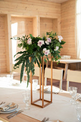 Bouquet with long branches of eucalyptus and flowers on the gold stand
