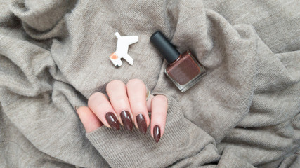 Female hands with long nails with brown nail polish