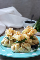 Bags of pancakes stuffed with herring, served with caviar, sour cream and dill on a wooden background. Rustic style.