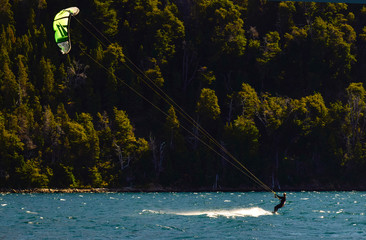 sobre las aguas de un lago rodeado de montañas boscosas una chica práctica kaysurf