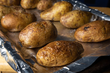 Baked potatoes on a foiled pan in the oven