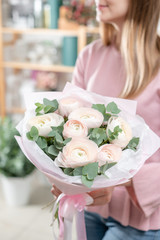 beautiful fresh cut bouquet of mixed flowers in woman hand. the work of the florist at a flower shop