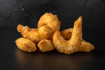 Deep fried royal prawn on black background. Snack to beer. Fast food.