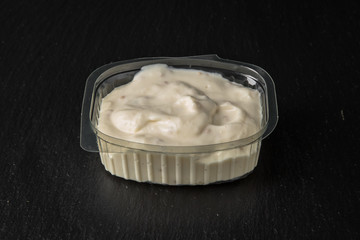 Sauce topping in plastic package for take away or food delivery isolated on a black background.