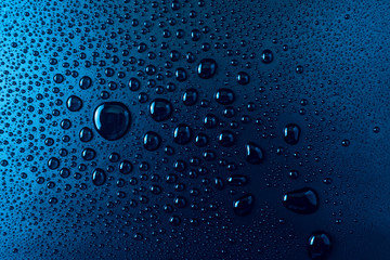 Drops of water on a blue glass texture background