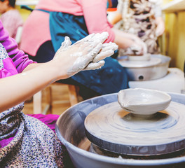 young potter hands working with clay on pottery wheel