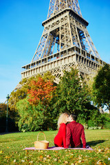 Romantic couple having picnic on the grass near the Eiffel tower