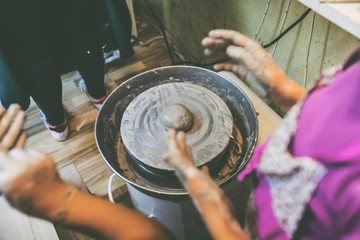 young potter hands working with clay on pottery wheel