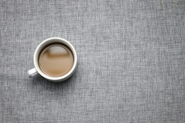 Cup of coffee on grey fabric surface close-up-background image