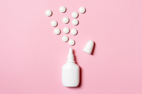 Spray for nose congestion treatment on pink background - cold, flu and medicine concept