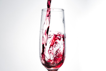 Pouring red wine isolated on white