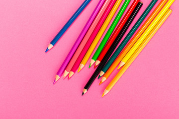 Drawing supplies: assorted color pencils, isolated on pink background