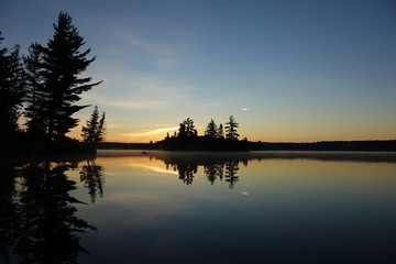 Fototapeta premium sunset on lake with silhouette of trees