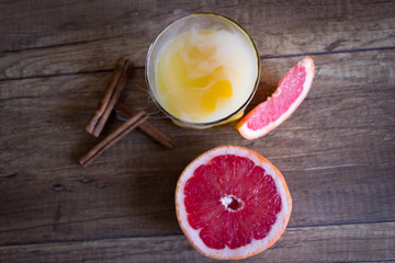 Fototapeta na wymiar Orange juice with grapefruit. A glass of grapefruit juice on a wooden background. Cinnamon Cocktail
