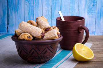 Clay bowl full of cakes and a cup of tea