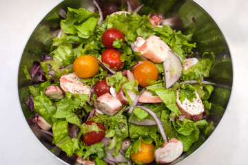 juicy summer salad with fresh herbs, cherry tomatoes, squid and red onion. Healthy nutrition and weight loss