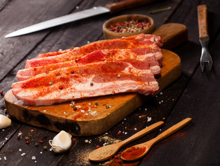Raw pork steak on a cutting board with spices.